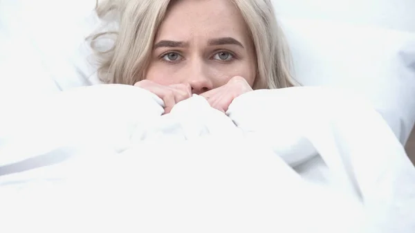 Young upset woman looking at camera in bed — Stock Photo