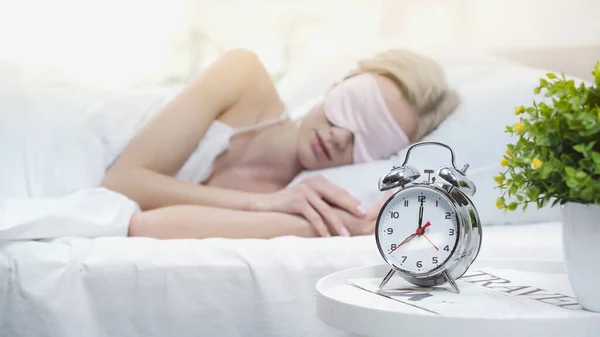 Jovem loira em máscara de dormir deitado na cama — Fotografia de Stock