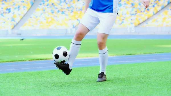 Cropped view of football player in shorts bouncing soccer ball with legs — Foto stock