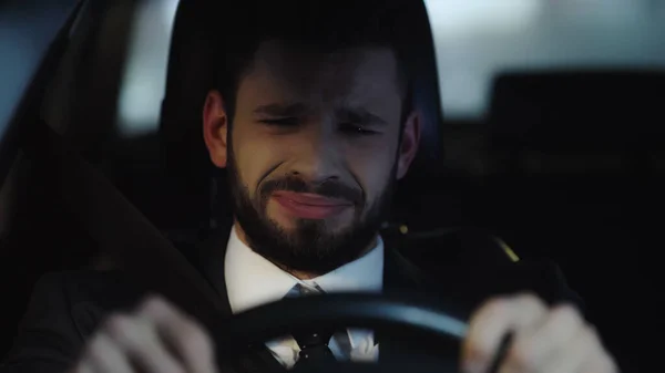 Frustrated businessman crying while driving car at night — Fotografia de Stock