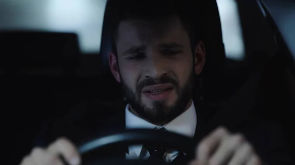 Stressed and crying businessman traveling in auto at night — Stock Photo