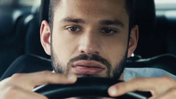 Tired man with sweaty forehead driving car while suffering from heat — Stock Photo