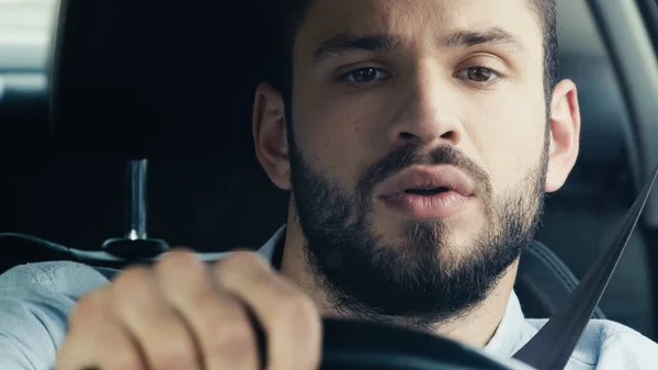 Young and concentrated man driving car and looking ahead — Fotografia de Stock