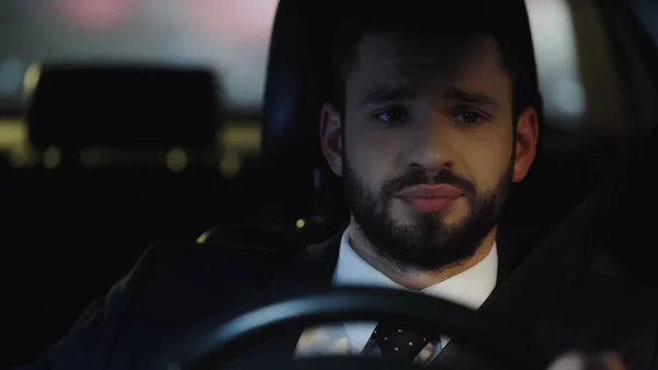 Portrait of upset businessman driving automobile at night — Photo de stock