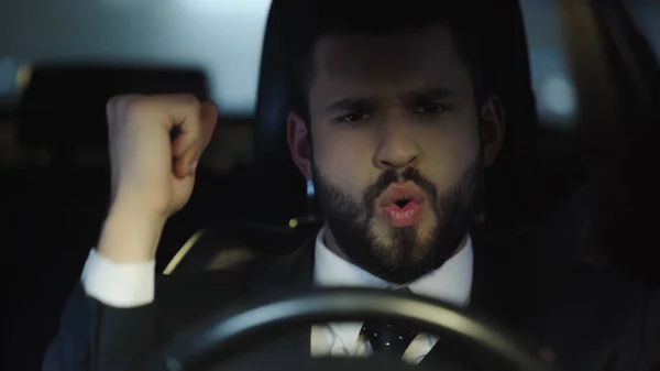 Excited businessman showing win gesture while traveling in car - foto de stock