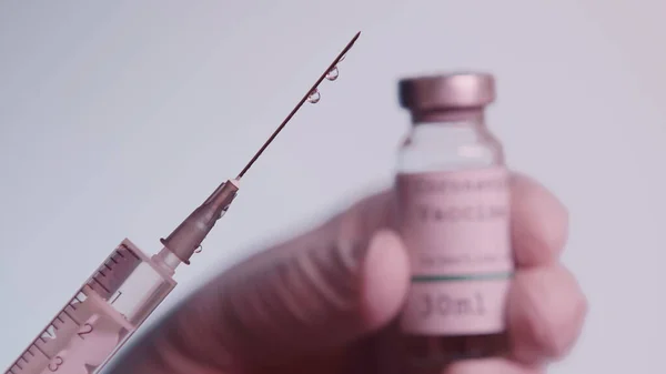 Cropped view of scientist holding syringe with vaccine and blurred bottle isolated on grey — Foto stock