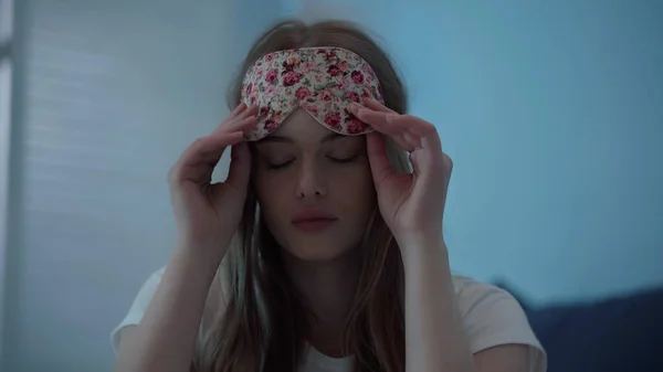 Young woman holding sleep mask at home at night - foto de stock