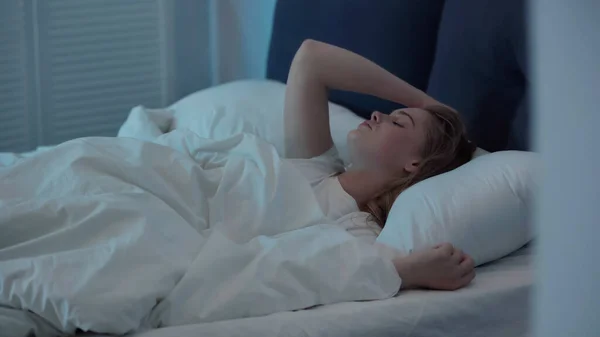 Young woman suffering from insomnia on bed at night — Foto stock