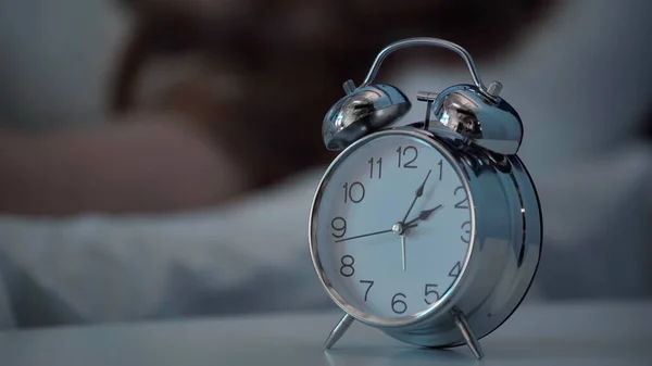 Alarm clock on bedside table at night — Stock Photo