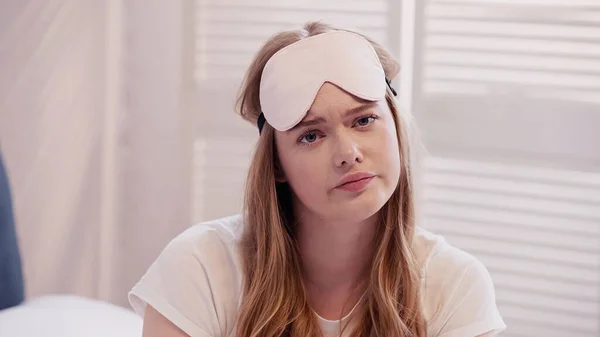 Sad woman in sleep mask looking at camera in bedroom in morning — Stock Photo