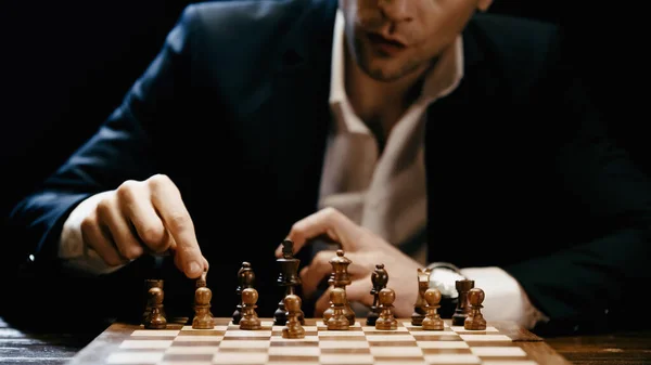Cropped view of businessman playing chess isolated on black — Photo de stock