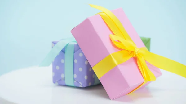 Nahaufnahme von verpackten Geschenkboxen mit Bändern auf blauem Hintergrund — Stockfoto
