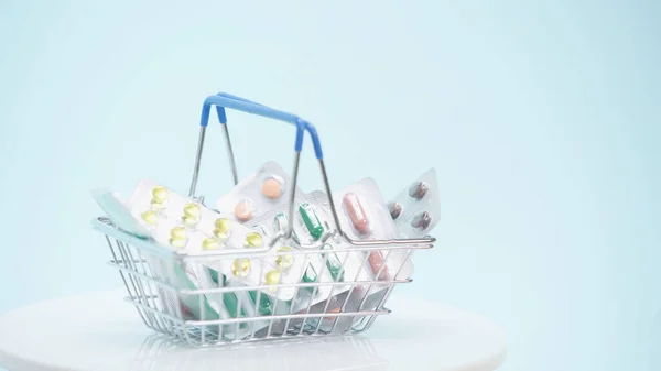 Small shopping basket with different medicaments on blue — Stock Photo