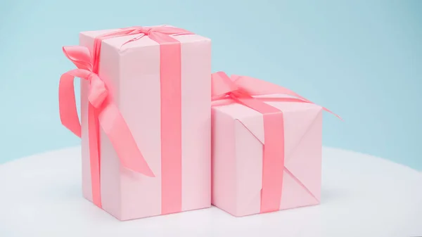 Праздничные подарочные коробки в розовой оберточной бумаге на голубом фоне — стоковое фото