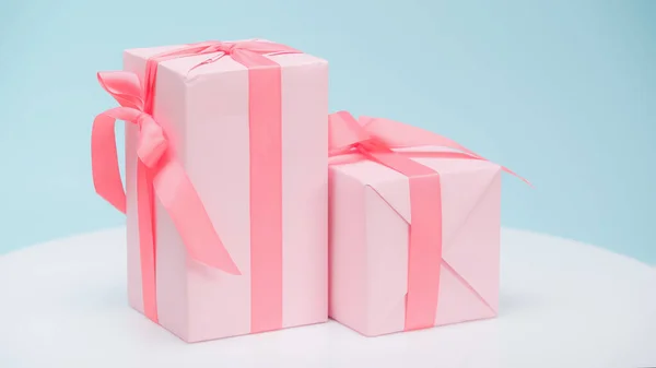 Festive gift boxes in pink wrapping paper on blue background — Stock Photo