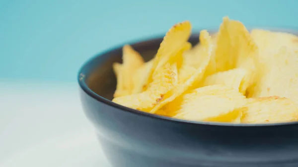 Cerrar la vista de las papas fritas crujientes y con surcos en un tazón azul con espacio para copiar - foto de stock