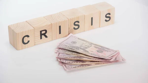 Dollarnoten in der Nähe von Holzwürfeln mit Krisenschrift auf weißem Hintergrund — Stockfoto