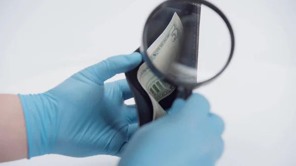 Cropped view of person holding magnifying glass near wallet with dollar banknote on white background — Stock Photo