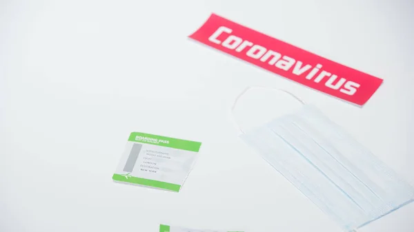 Ripped boarding pass near medical mask and coronavirus lettering on white — Stock Photo