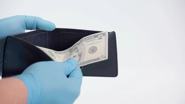 Vista recortada de la persona en guantes de látex con billete de dólar y billetera en blanco - foto de stock