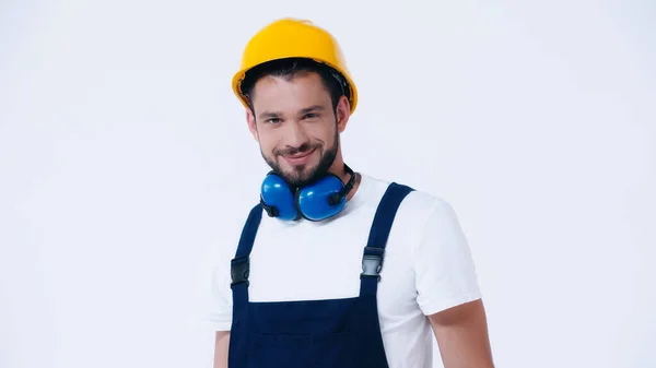Smiling foreman in overalls and helmet looking at camera isolated on white — Stock Photo