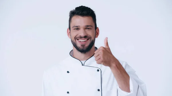 Збуджений чоловік в куртці шеф-кухаря показує великий палець вгору і посміхається на камеру ізольовано на білому — стокове фото