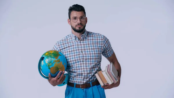 Estudiante nerd con globo y pila de libros mirando a la cámara aislada en gris - foto de stock