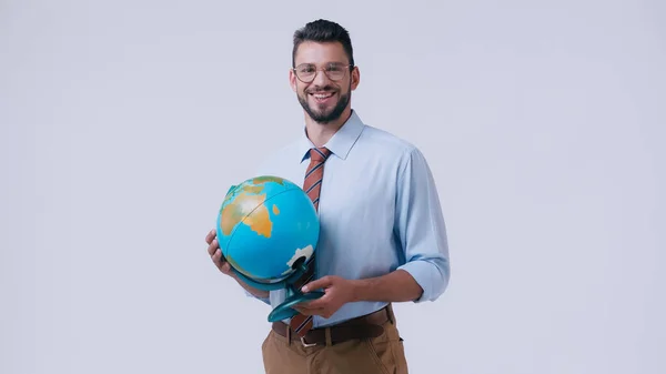 Cheerful teacher in eyeglasses holding globe and smiling at camera isolated on grey — Stock Photo