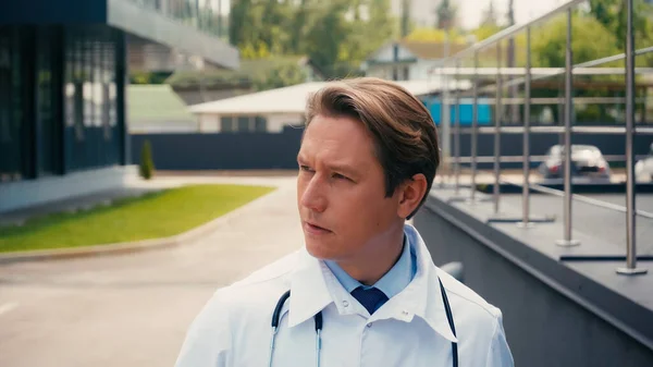 Portrait of doctor with stethoscope looking away outdoors — Stock Photo