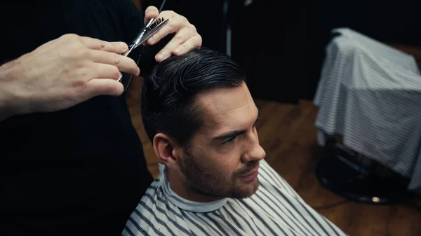 Taglio di parrucchiere capelli di uomo in parrucchiere cape in salone — Foto stock