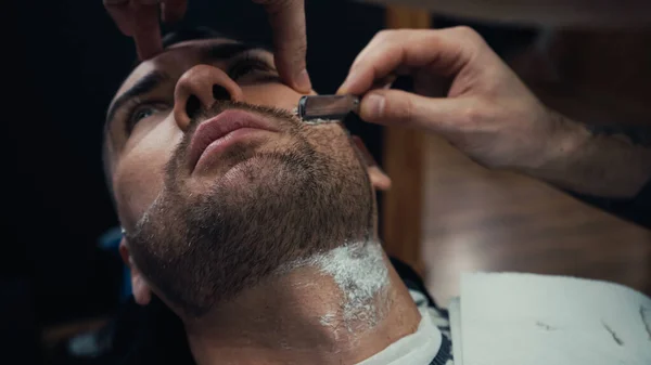 Barba da barba di barbiere di cliente con rasoio in salone — Foto stock