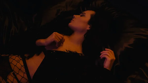Вид зверху сексуальна жінка в ажурних колготках лежить на ліжку — стокове фото