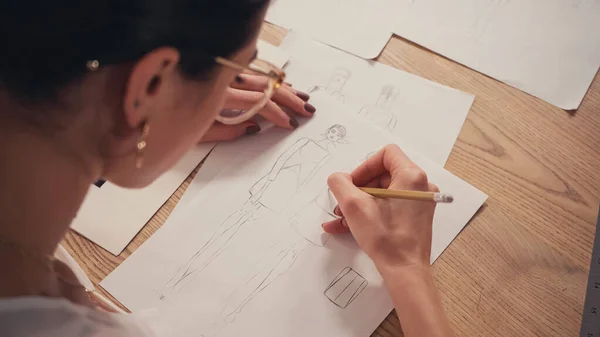 High angle view of seamstress drawing sketches in atelier — Stock Photo