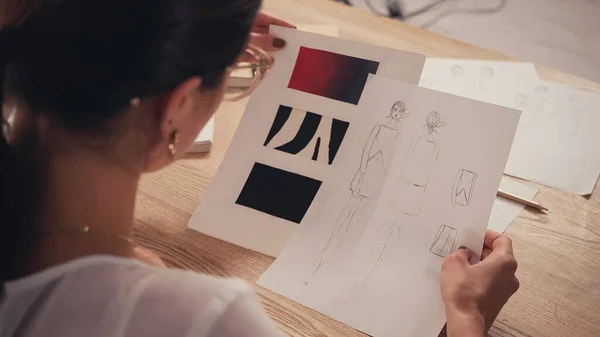 High angle view of burred designer holding sketches in atelier — Stock Photo