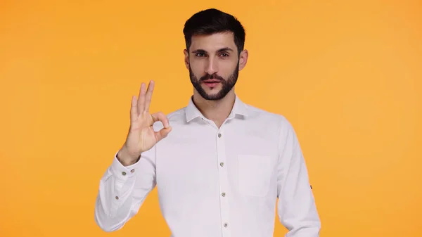 Bearded man in white shirt showing ok sign isolated on yellow — Stock Photo
