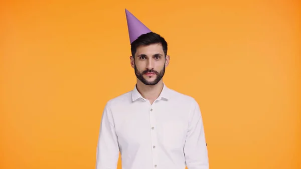 Bearded man in party cap looking at camera isolated on yellow — Stock Photo