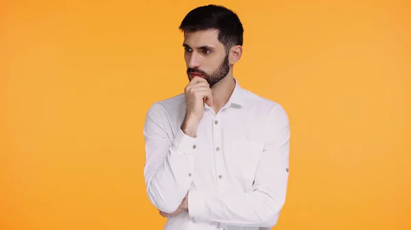 Pensive man in white shirt touching beard while thinking isolated on yellow — Stock Photo