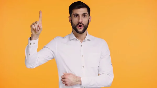 Uomo barbuto in camicia bianca che mostra il segno dell'idea mentre guarda la fotocamera isolata sul giallo — Foto stock