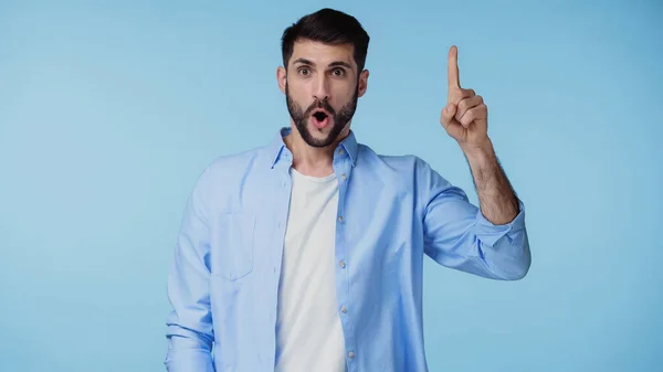 Homme barbu en chemise montrant signe d'idée tout en regardant la caméra isolée sur bleu — Photo de stock