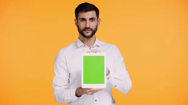 Bearded man in shirt holding digital tablet with green screen isolated on yellow — Stock Photo