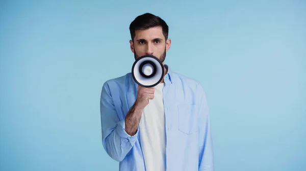 Бородатий чоловік робить оголошення в гучномовці ізольовано на синьому — стокове фото