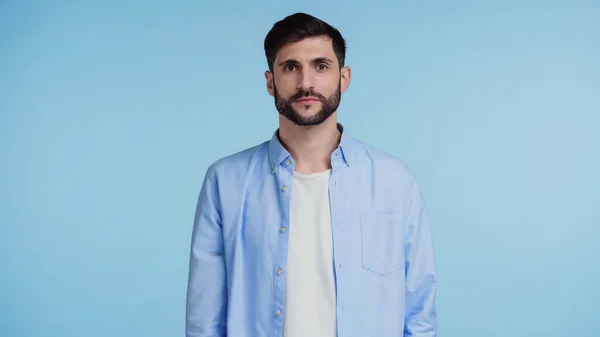 Confident and bearded man in shirt looking at camera while standing isolated on blue — Stock Photo