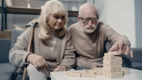 Verschwommenes und demenzkrankes Senioren-Paar spielt gemeinsam in Holzklötzen — Stockfoto
