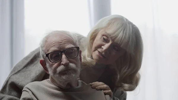 Mujer mayor calmando marido en gafas con demencia - foto de stock