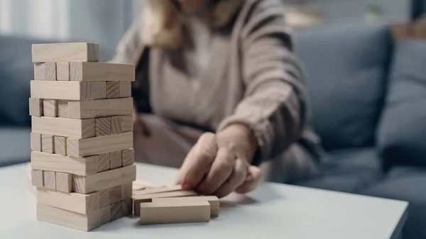Vue recadrée de la femme âgée avec la démence jouant dans les blocs jeu de bois — Photo de stock