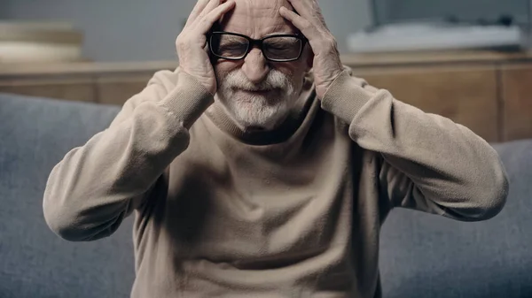 Бородатий старший чоловік з деменцією страждає від головного болю і торкається голови — стокове фото