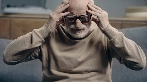 Bearded senior man with dementia having headache and touching head — Stock Photo