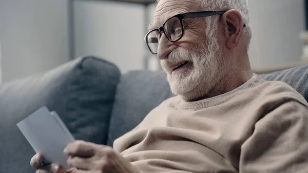 Heureux homme âgé avec démence regardant des photos à la maison — Photo de stock