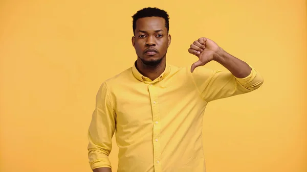 Enttäuschter afrikanisch-amerikanischer Mann im Hemd zeigt Abneigung isoliert auf Gelb — Stockfoto