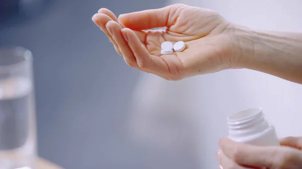 Cropped view of woman holding pills in hand — Stock Photo